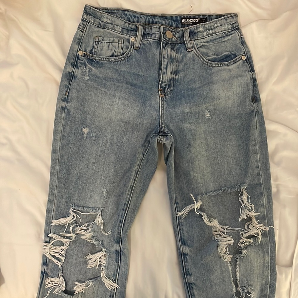 Light denim jean with rips at the knees